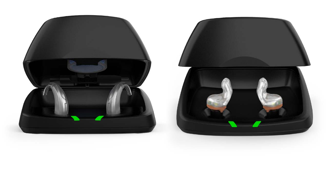 Two Chargers open case, one with RIC hearing aids and the other custom hearing aids.