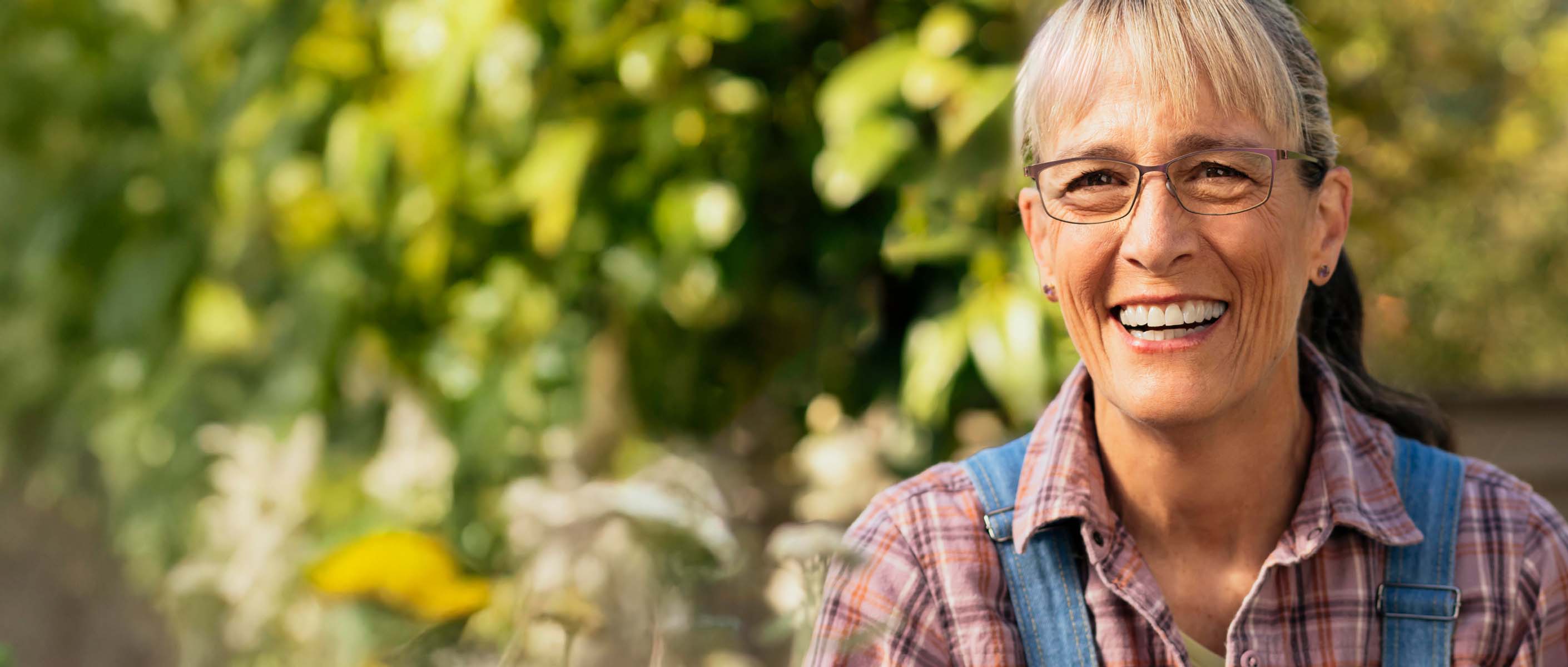 Daphne Smiling with greenery behind her.