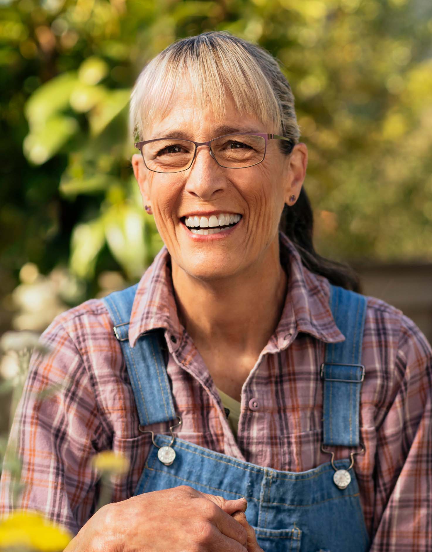 Daphne Smiling with greenery behind her.